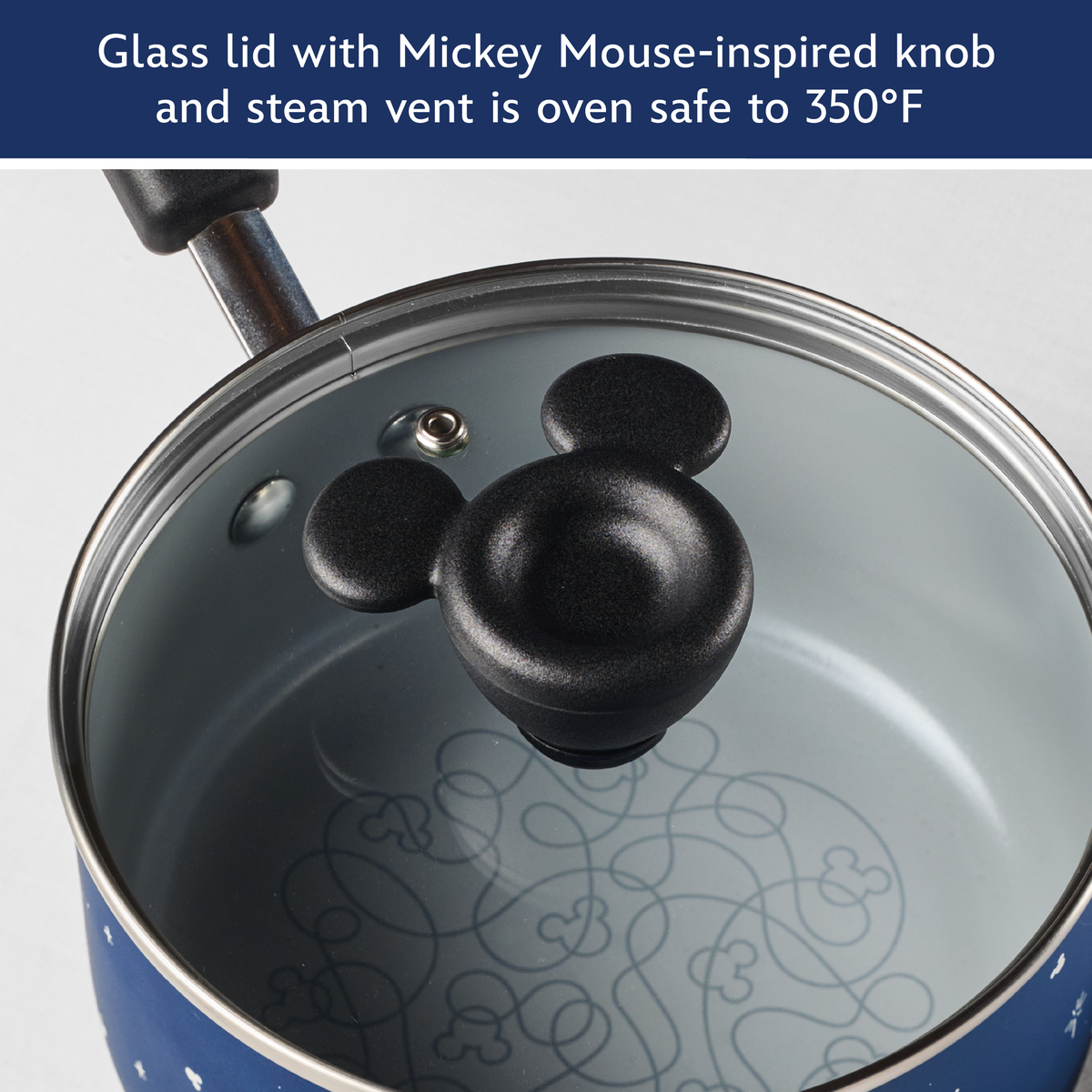 Glass lid with Mickey Mouse-inspired knob and steam vent is oven safe to 350°F: lid resting on the blue saucepan