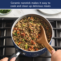 Ceramic nonstick makes it easy to cook and clean up delicious meals: blue saucepan of quinoa, rice and vegetables stirred with a wooden spoon on a gas stove