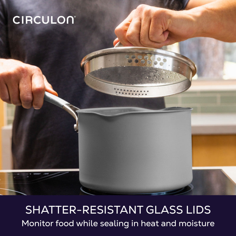 Shatter-resistant glass lids, monitor food while sealing in heat and moisture: hand lifting the straining lid off a gray saucepan on an induction cooktop