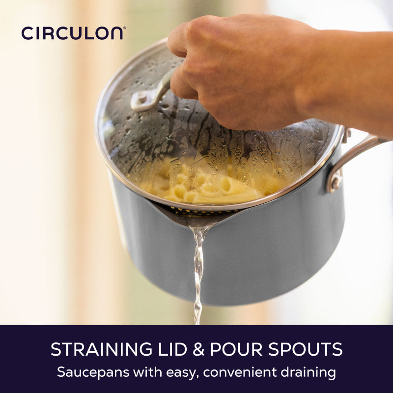 Straining lid and pour spouts, saucepans with easy, convenient draining: water pouring from a gray saucepan of pasta through its straining lid
