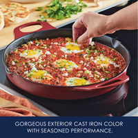 Gorgeous exterior cast iron color with seasoned performance: hand garnishing eggs baked in tomato sauce with feta in a red cast iron skillet