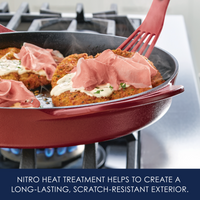 Nitro heat treatment helps to create a long-lasting, scratch-resistant exterior: red cast iron skillet of breaded cutlets topped with prosciutto on a gas burner