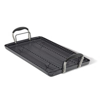 Angled view of the dark gray 10 x 18-inch double burner griddle with black handle grips and a wire rack set on top