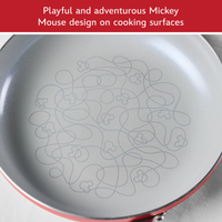 Playful and adventurous Mickey Mouse design on cooking surfaces: close-up of a red frying pan's gray interior printed with a looping line and Mickey heads
