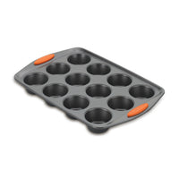 Angled view of the gray 12-cup muffin pan with orange handles