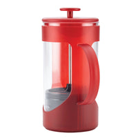 Side view of the red French press showing the handle, clear carafe and gray filter cup inside